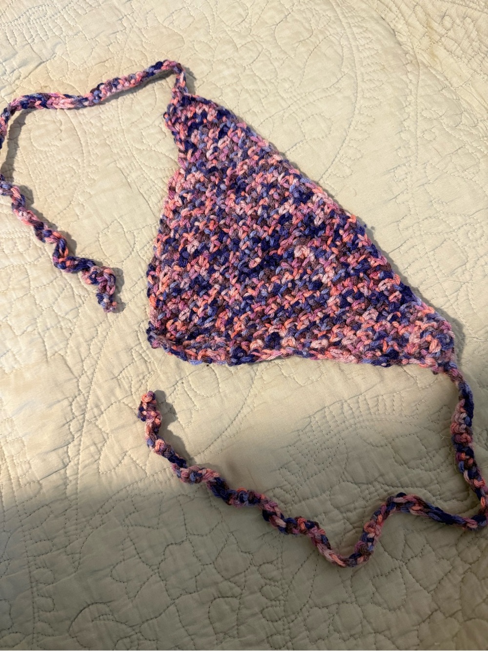 Handmade crochet bandana in pink, blue, and purple marbled yarn.